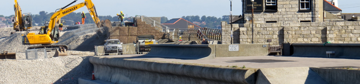 photo of flood defence work being carried out in 2014 overlook Chesil Beach on the doorstep of the Cove House Inn public house at Portland, Dorset