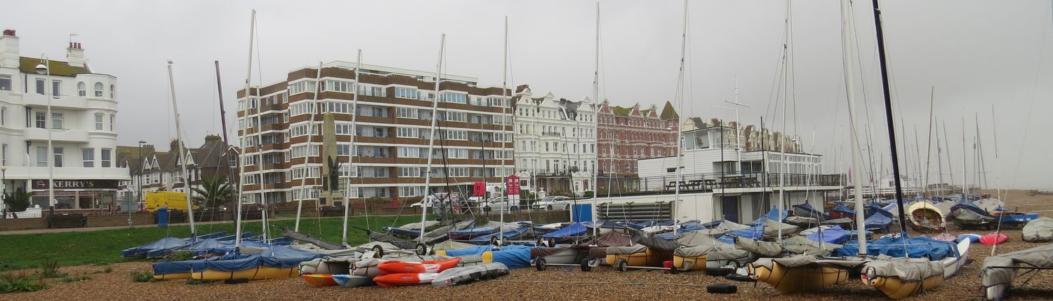 Boats on Bexhill beach with flats behind